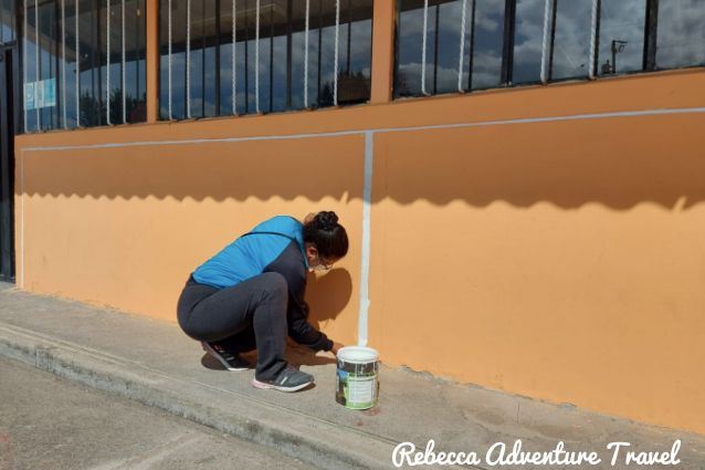 community-member-painting-in-minga-at-Ulloa-School