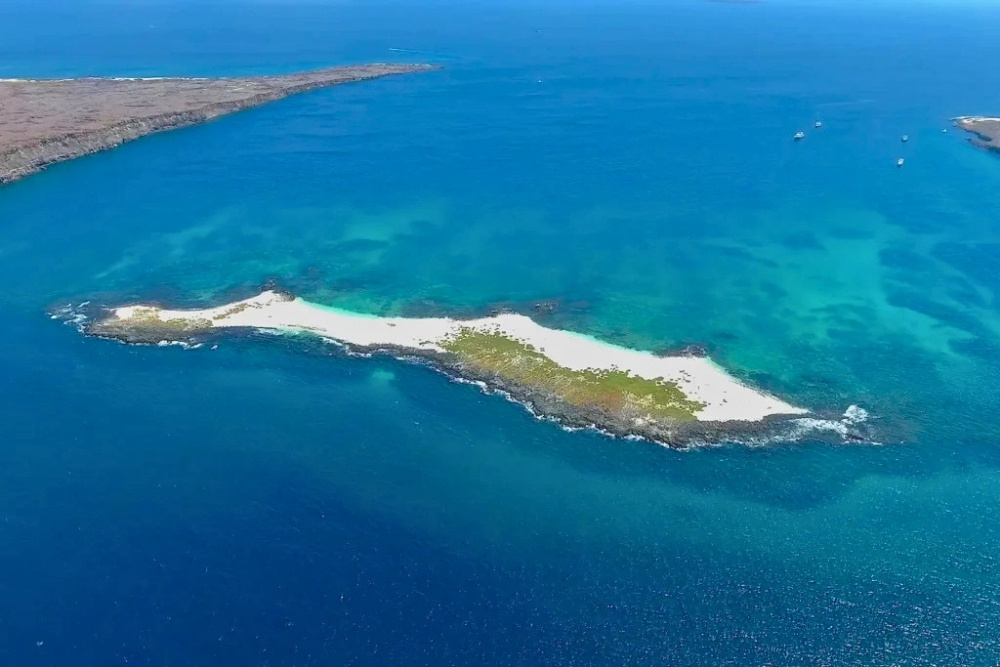 Aerial view of sandy reef at mosquera islet surrounded by vibrant ocean waters among premier Galapagos diving sites