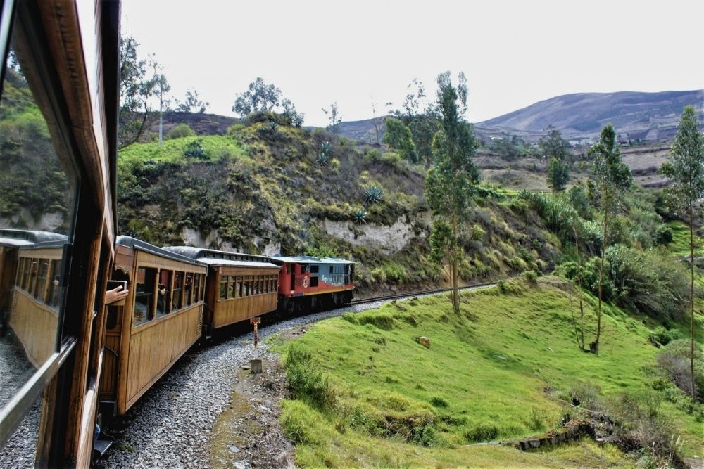 Historic wooden Devil nose train Ecuador winding along a scenic mountain track through lush green Andean hillsides