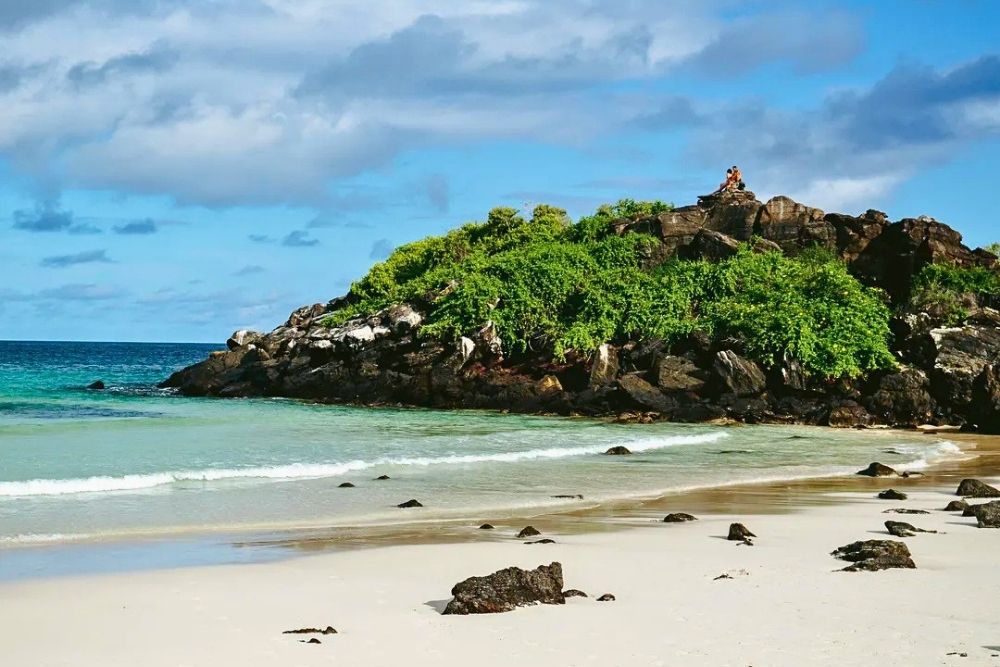 White sand beach and rocky hills at Puerto Chino on San Cristobal Island during a 6 day galapagos itinerary