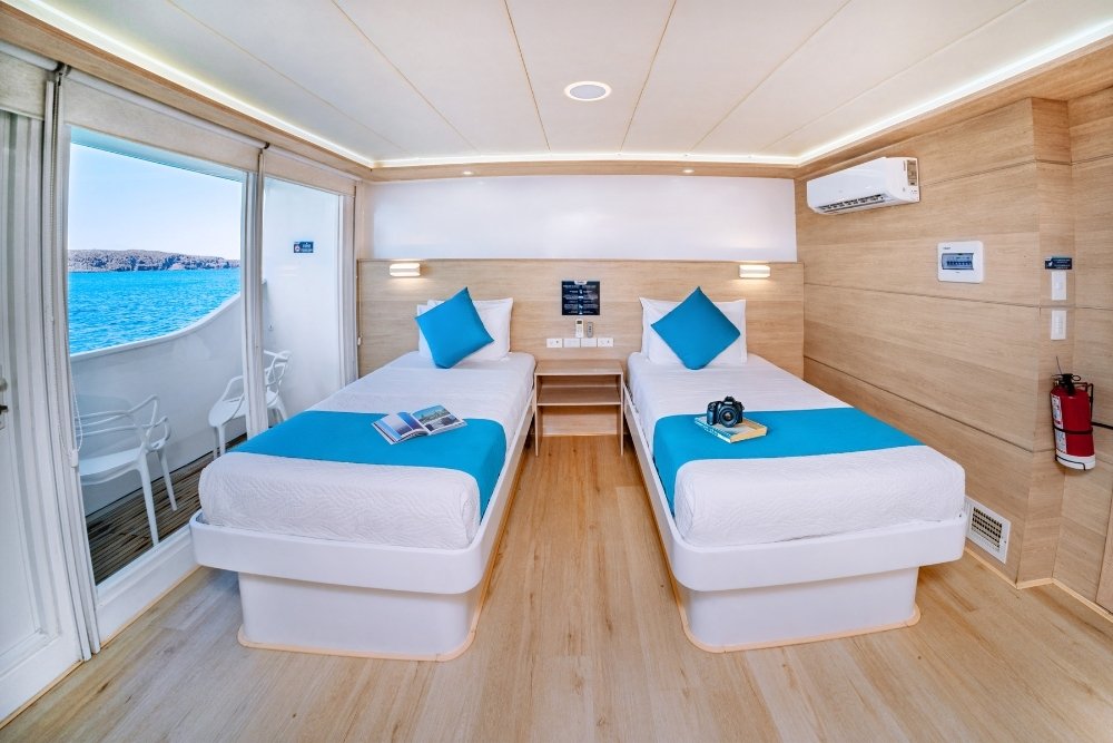 cozy room with twin beds aboard the treasure of galapagos cruise