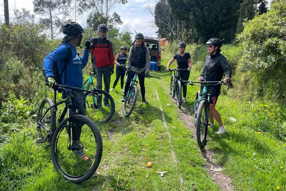 Travelers preparing for a moderate mountain biking adventure during an Otavalo tour near Imbabura Volcano