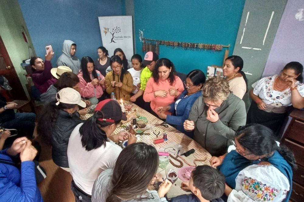Travelers making tagua necklaces at the Sumak Muyu workshop in La Calera Kichwa community, Cotacachi