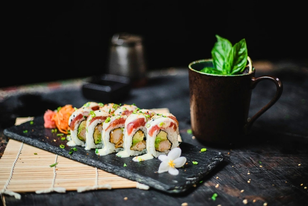 Fresh Ecuadorian-style sushi rolls artfully presented on a black slate platter during a 7 day Galapagos food tour