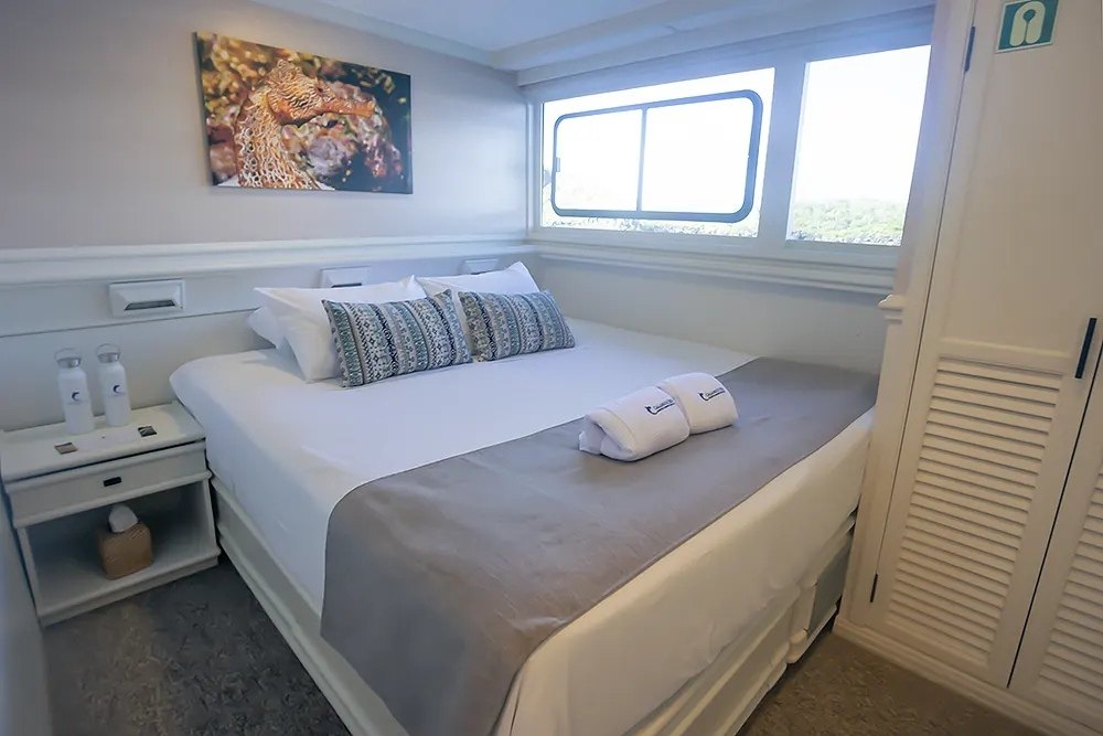 Cozy bedroom for a couple aboard the Galapagos Sky.