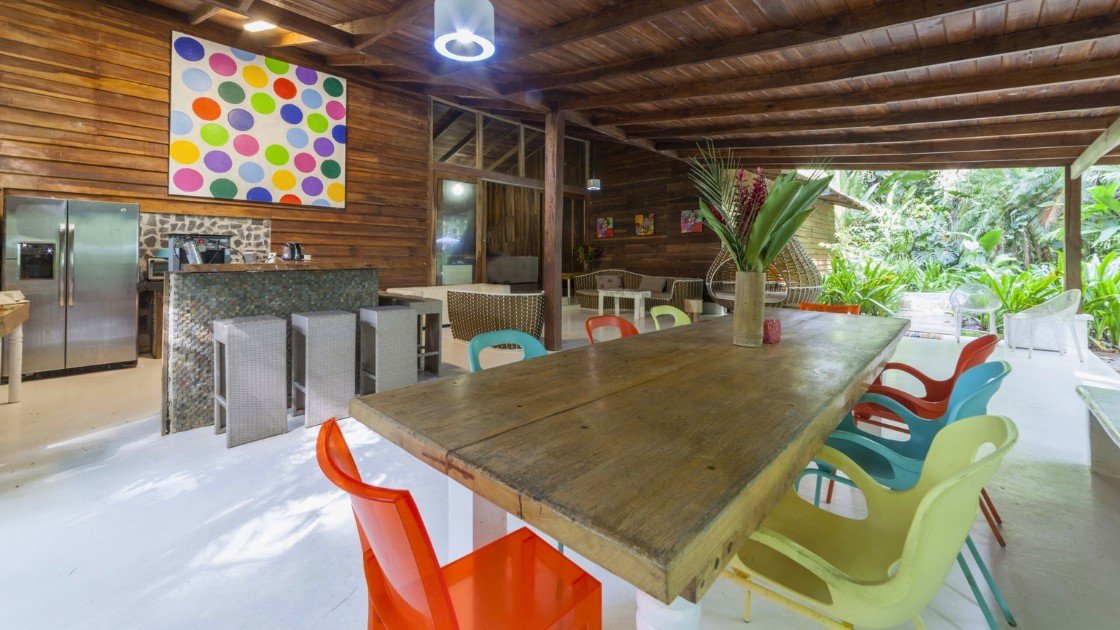 Contemporary open-air dining space with colorful chairs and wooden finishes at Le Camaleon Boutique Hotel Costa Rica