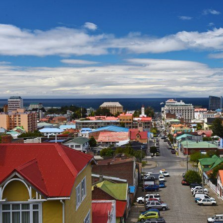 Punta-Arenas Rebecca Adventure Travel Elevated view of colorful rooftops in coastal Punta Arenas overlooking the Strait of Magellan under a blue sky