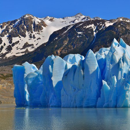 torres-del-paine-grey-glacier Rebecca Adventure Travel Massive bright blue ice wall of Grey Glacier in Torres del Paine with snow-dusted Patagonian mountains in background