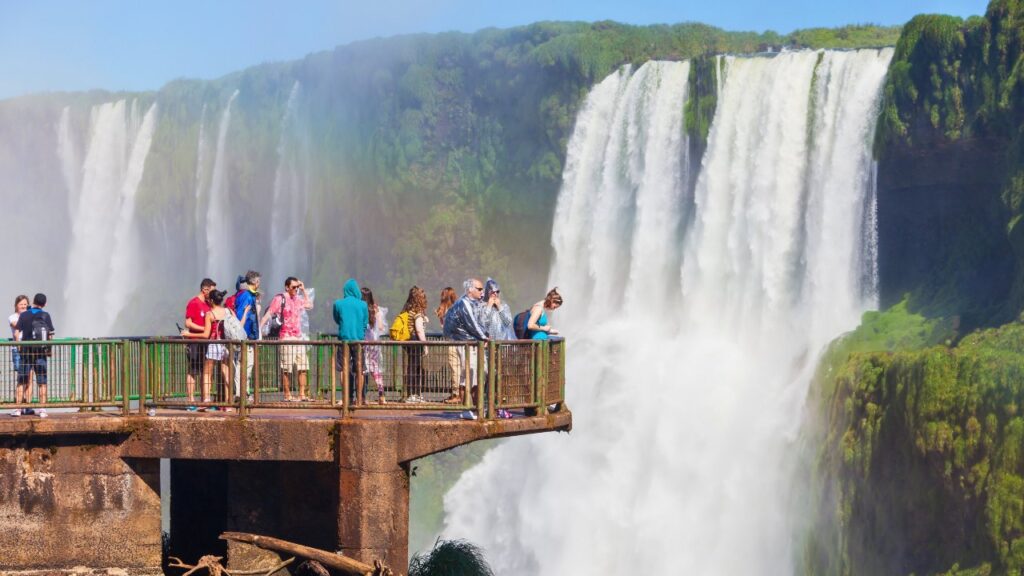 tourists taking in views of majestic thundering cascades on a luxury south america adventure at iguazu falls