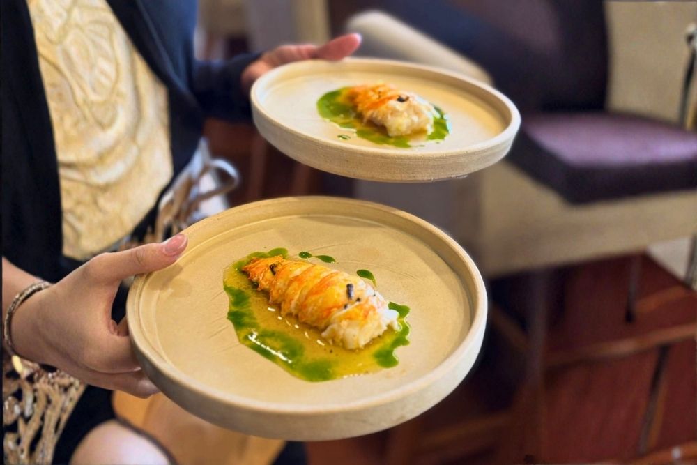 Fine dining dish featuring delicate lobster meat in vibrant herb oil at Quitu Identidad Culinaria Ecuador Luxury Experience