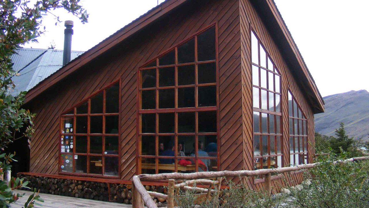 Rustic wooden mountain lodge with large lattice windows at Refugio Los Cuernos in Torres del Paine Chilean Patagonia