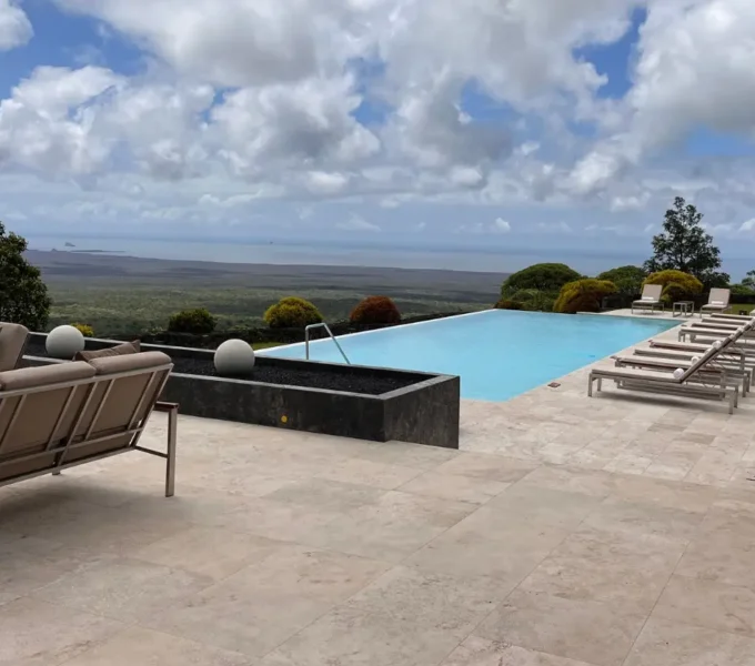 infinity pool and terrace overlooking volcanic landscape at one of the galapagos luxury hotels.