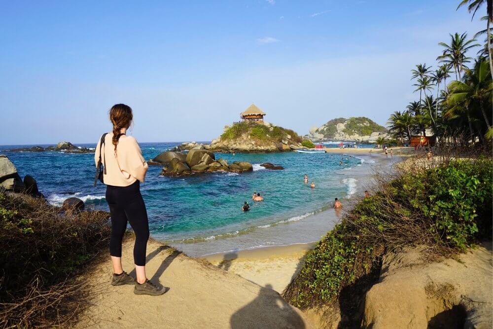 traveler enjoying the view at cabo san juan, tayrona national park, a top spot for the best time to visit colombia