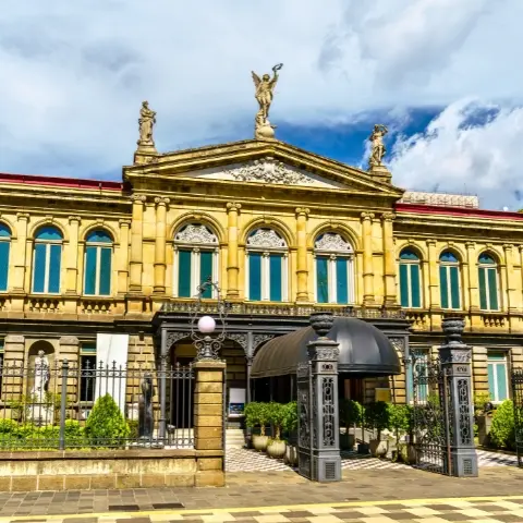 San-Jose-Costa-Rica Rebecca Adventure Travel Historic neoclassical facade of the National Theatre under cloud-dappled blue skies in San Jose Costa Rica