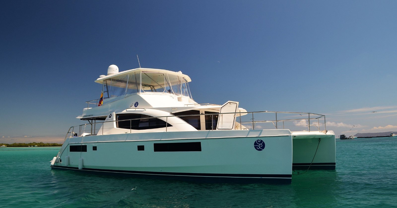 Inter island transportation galapagos luxury catamaran used for inter-island transportation in galapagos cruising between islands on clear turquoise water