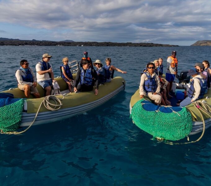 travelers riding pangas between islands on one of the best galapagos island-hopping tours