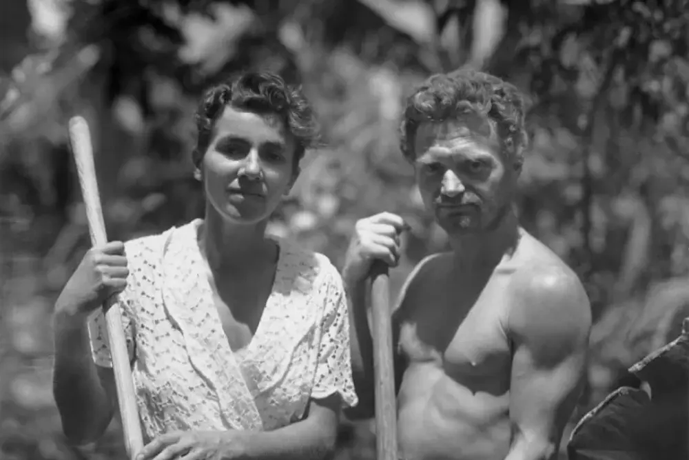 a black and white photo of dore strauch and freidrich ritter holding tools outdoors during their time on floreana.