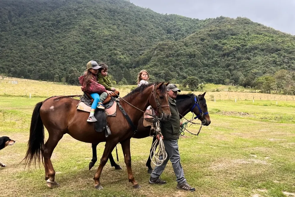 family horseback riding near pululahua volcano in ecuador, enjoying the scenic landscape of the andean countryside