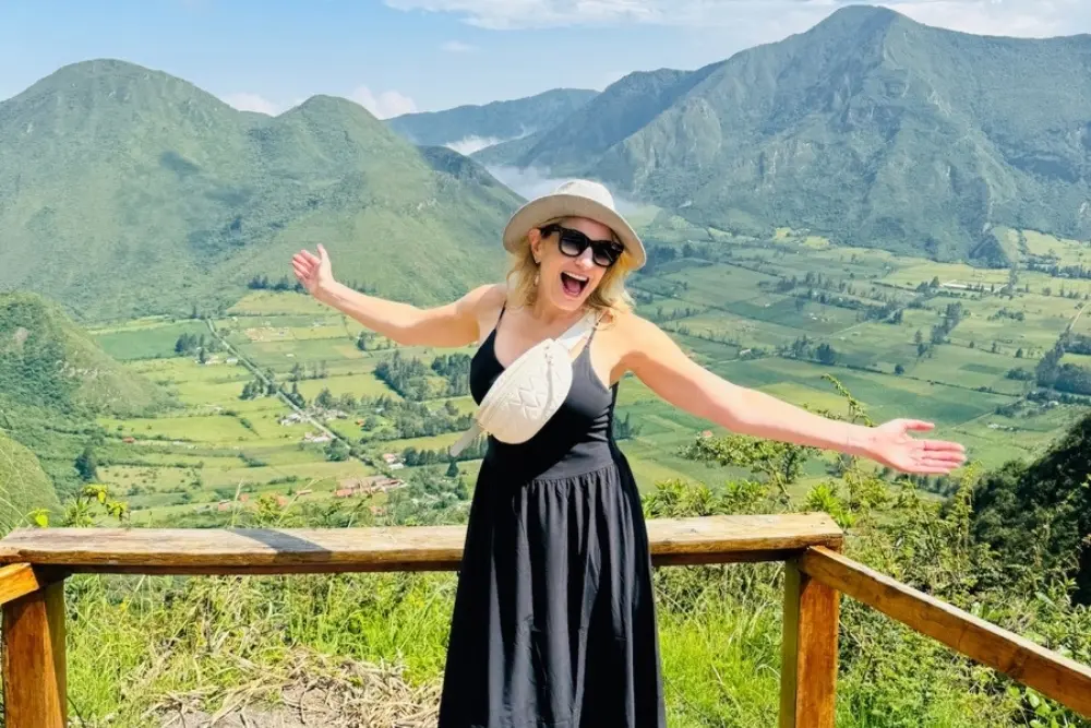 traveler enjoying the stunning view of pululahua crater with mountains and lush landscape in the background