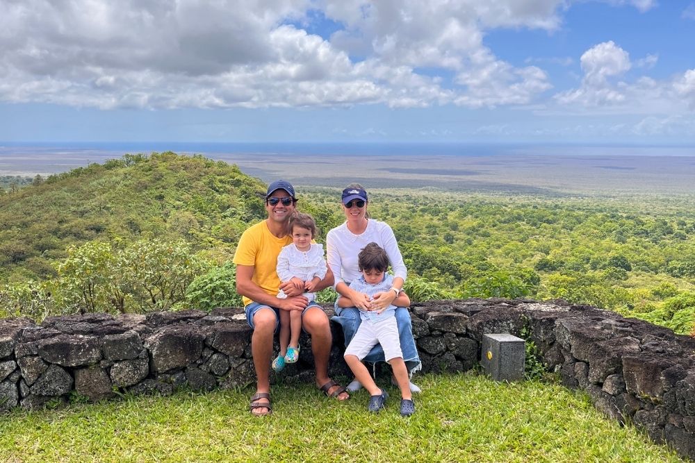 family enjoying panoramic views from pikaia lodge, overlooking lush galapagos highlands and volcanic landscapes.