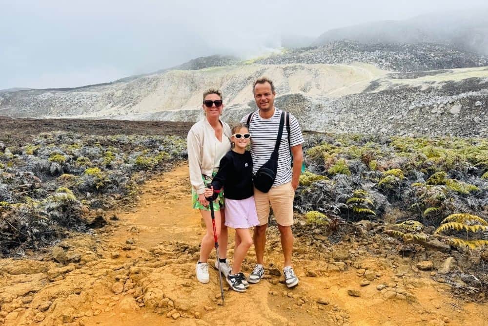 family hiking near a volcanic crater on isabela island in the galapagos, surrounded by dramatic lava landscapes and highland scenery