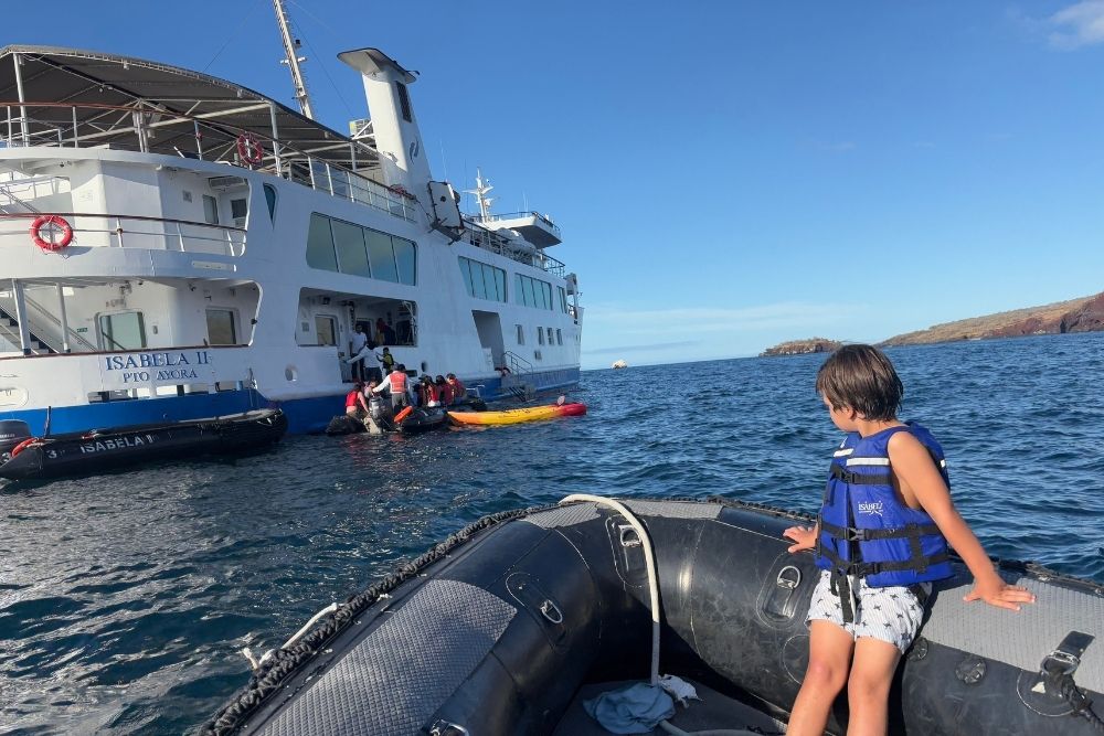 kid wearing a life jacket boarding the galapagos cruise isabela ii