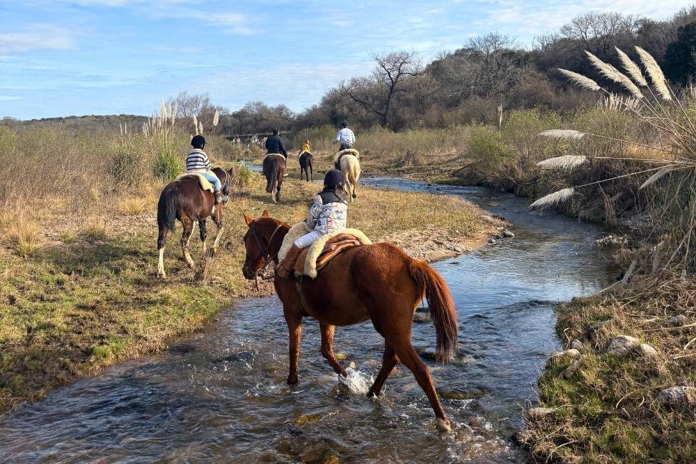 children riding horses across rivers in the pampas of cordoba argentina