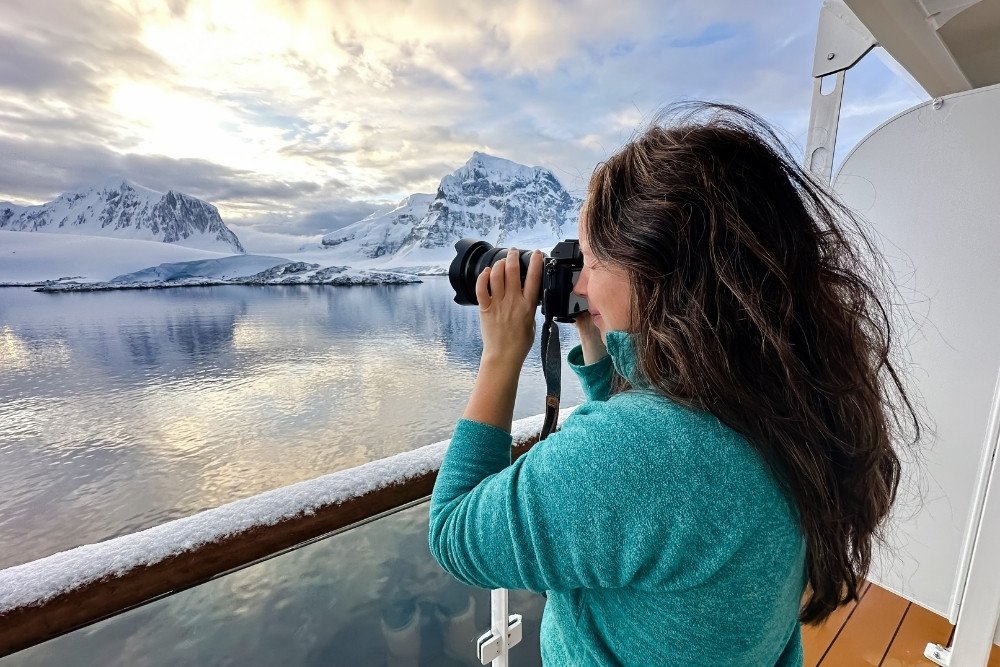 girl taking photographs at the observation deck on the antarctic cruise