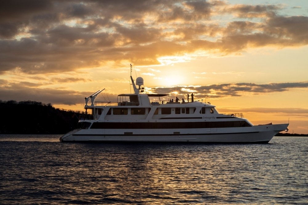 integrity yacht sailing to open waters at sunset