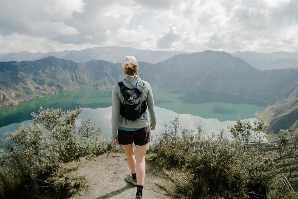 hiker overlooking the crater lake during the best time to trek quilotoa in ecuador